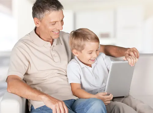 dad and son sitting together learning on a tablet